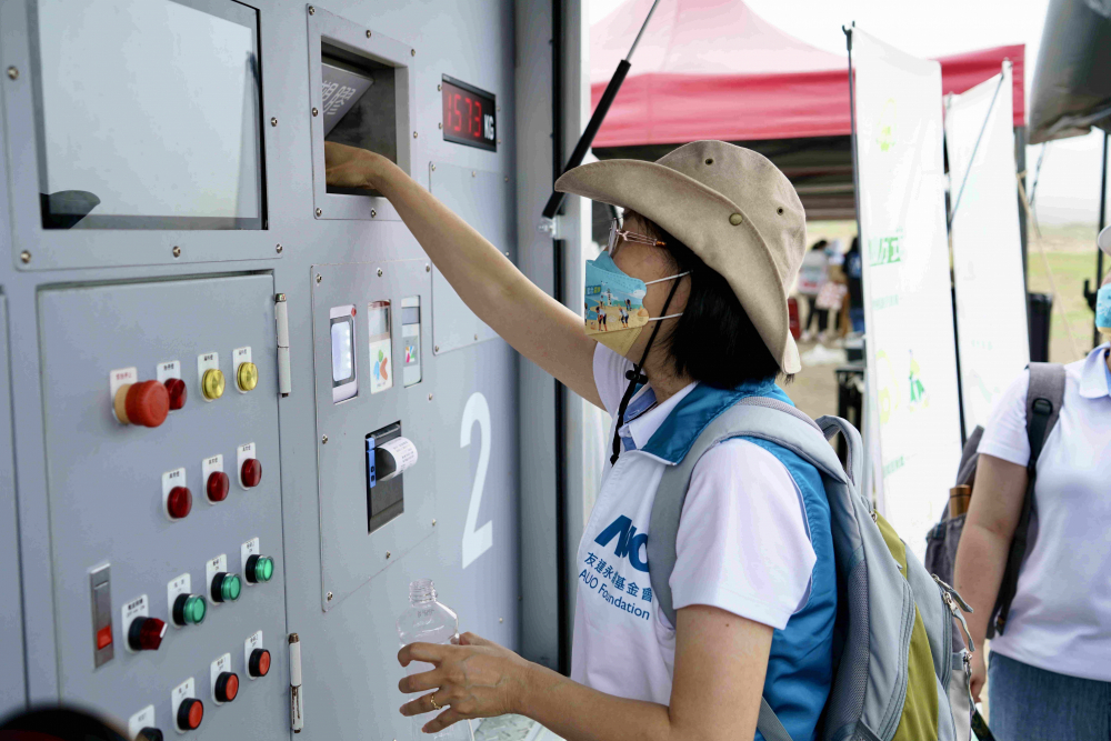 志工們將拾起的寶特瓶投入「好歸塑專車」，讓廢棄塑料空瓶可以直接粉碎、縮小體積，未來將可再製成購物袋、寶特衣、悠遊卡等生活用品