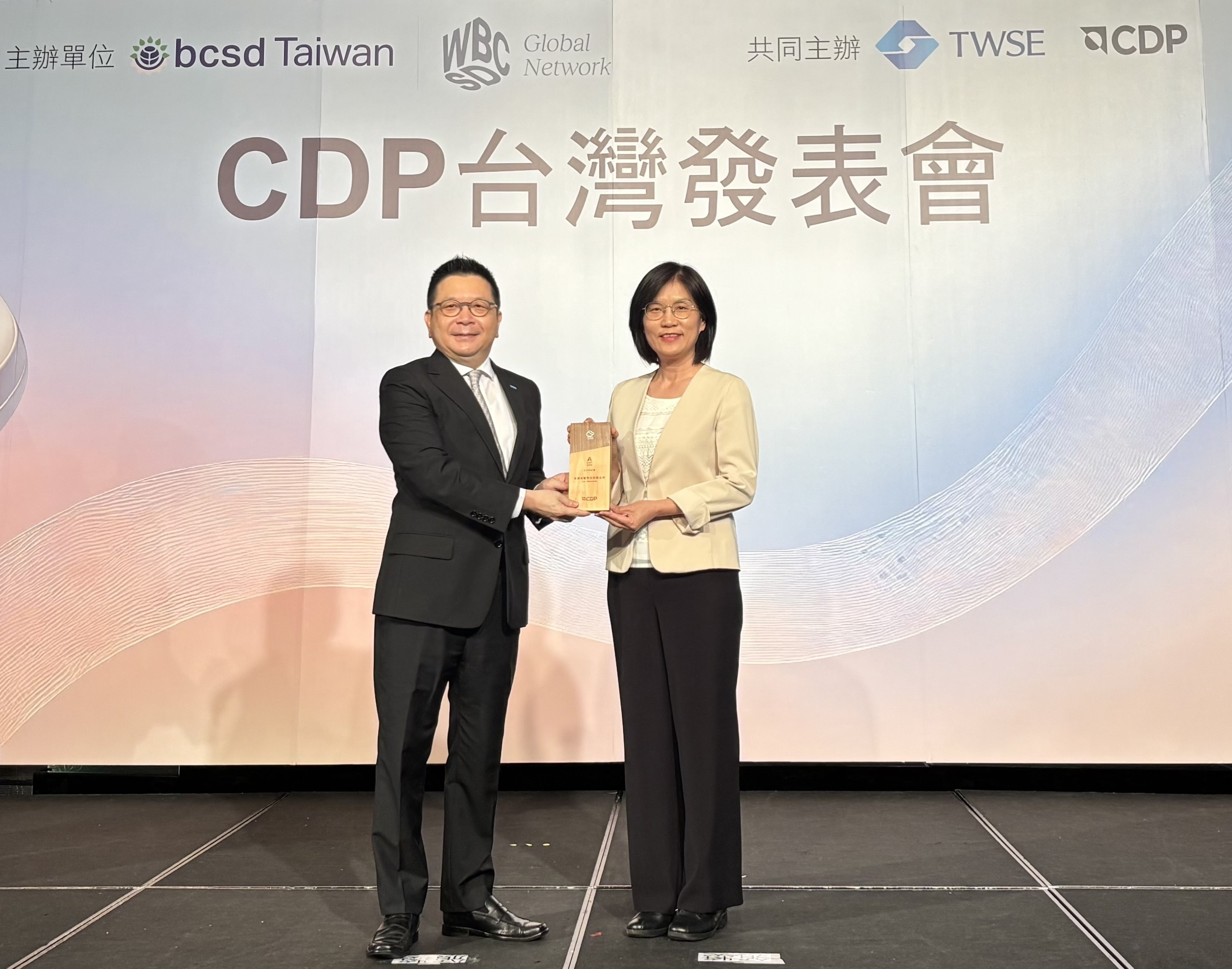 友達永續成果再獲國際評比肯定，獲頒CDP氣候與水資源雙項領導力評級。今由臺灣證券交易所董事長林修銘（左）頒獎，友達光電永續長古秀華（右）代表受獎